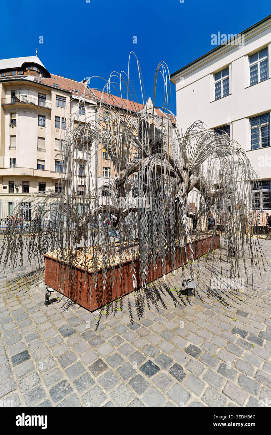 Les visiteurs explorent le mémorial de l'arbre de vie devant la synagogue de la rue Dohany à Budapest. La sculpture honore la mémoire des victimes de l'Holocauste. Banque D'Images