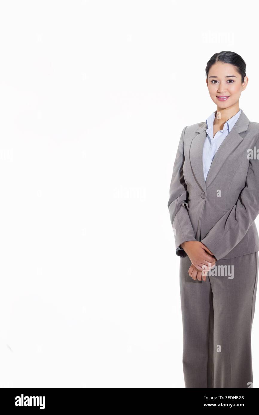 Femme asiatique adulte posant en studio portant un costume gris clair et un chemisier bleu clair, espace copie. Headshot, professionnel, entreprise, minimaliste, propre, donc Banque D'Images