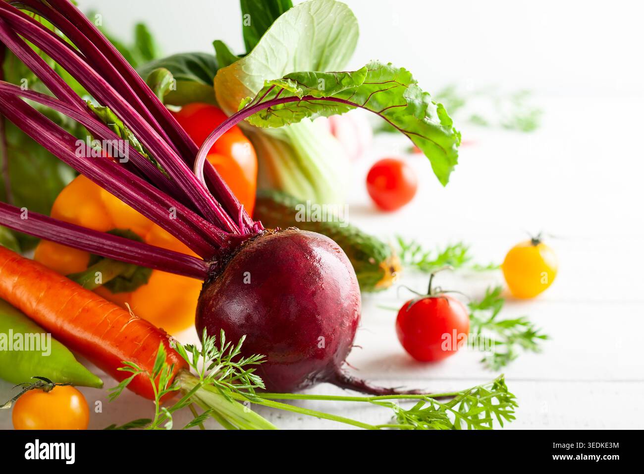 Différents types de légumes frais et d'herbes sur un fond en bois blanc. Concept de saine alimentation, légumes frais. Banque D'Images