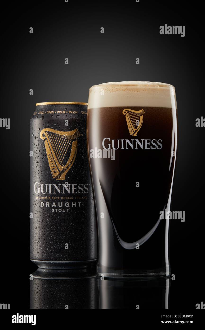 Lerwick, Écosse - 12 février 2023 : Guinness tirante canette et verre de pinte photographiés dans un cadre d'éclairage de studio spectaculaire contre un fond sombre Banque D'Images