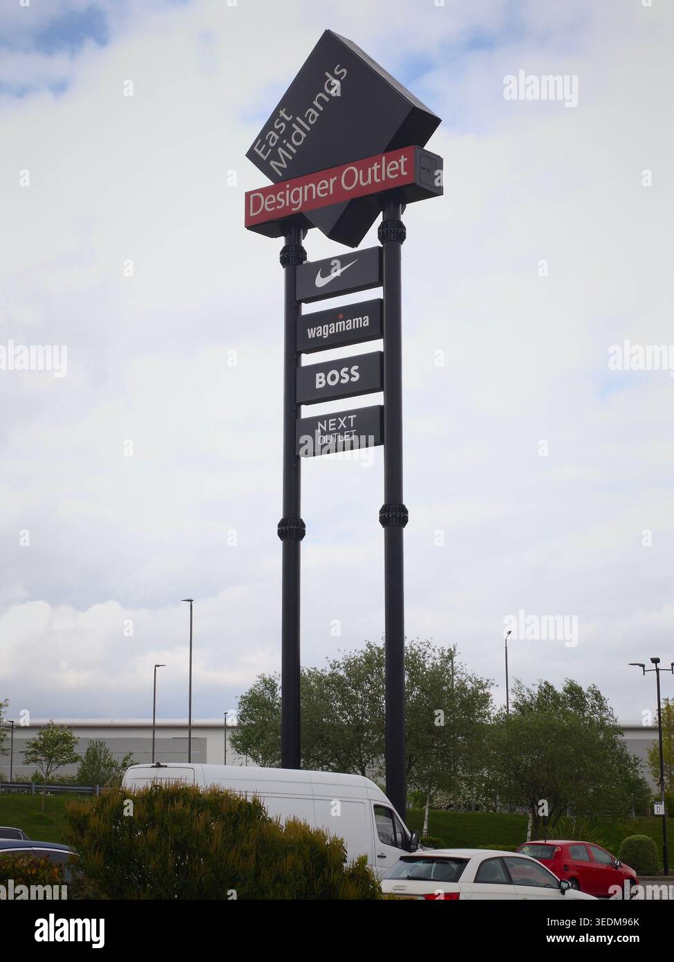 SOUTH NORMANTON, Royaume-Uni - 6 MAI 2026 : le panneau totem de l'entrée principale au East Midlands Designer Outlet. La destination de shopping, gérée par McArthurGlen, est un centre commercial majeur pour les régions du Derbyshire et du Nottinghamshire. Photographié au cours d'une période d'activité importante sur le site, suite à l'ouverture récente de nouvelles franchises alimentaires et de boissons et à la restructuration en cours sur le marché britannique de la vente au détail. Banque D'Images