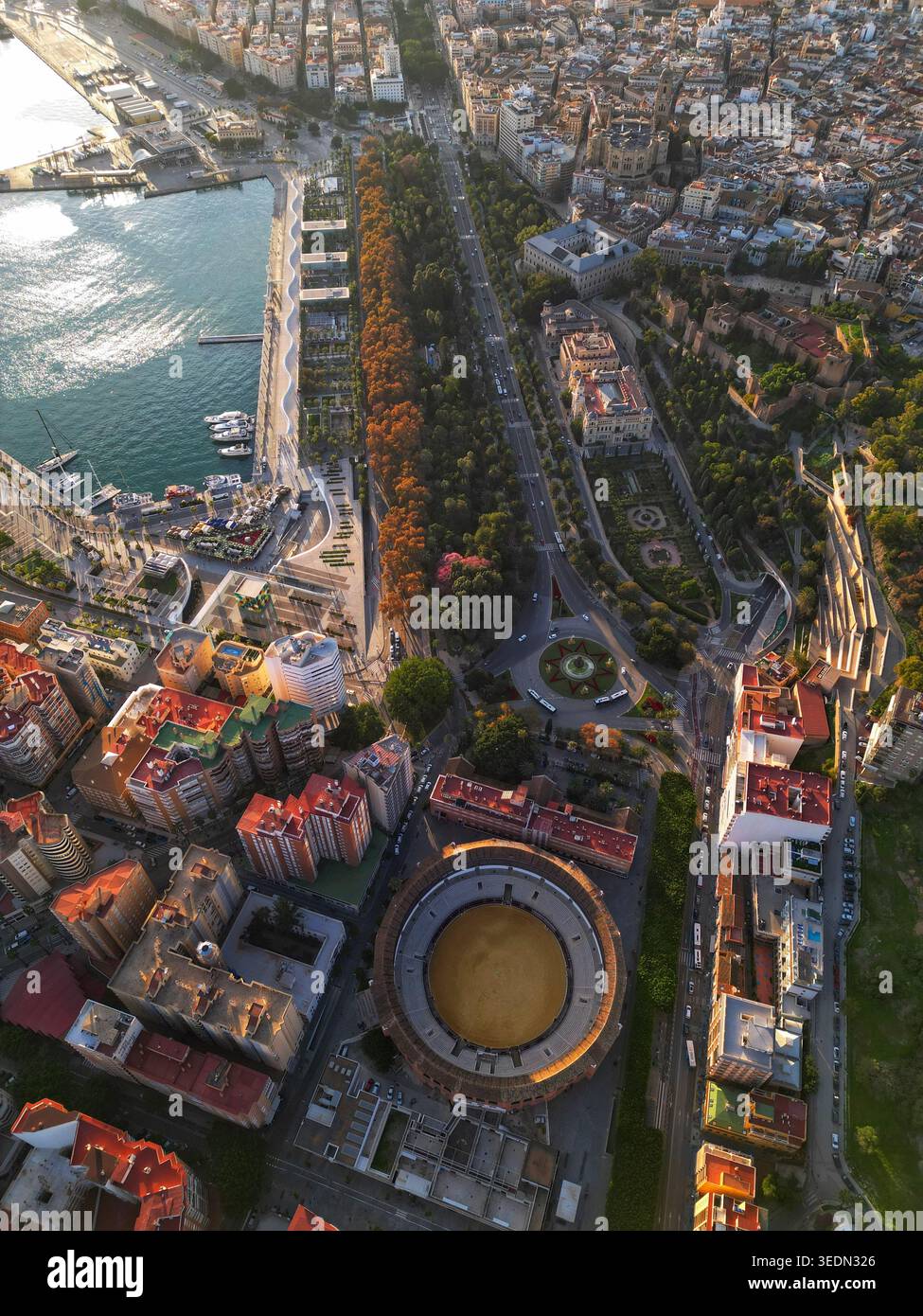 Vue aérienne de la Plaza de toros de la Malagueta arène, le parc luxuriant de la ville, et la zone portuaire sous la lumière chaude du soleil à Malaga, Andalousie, Espagne. Banque D'Images