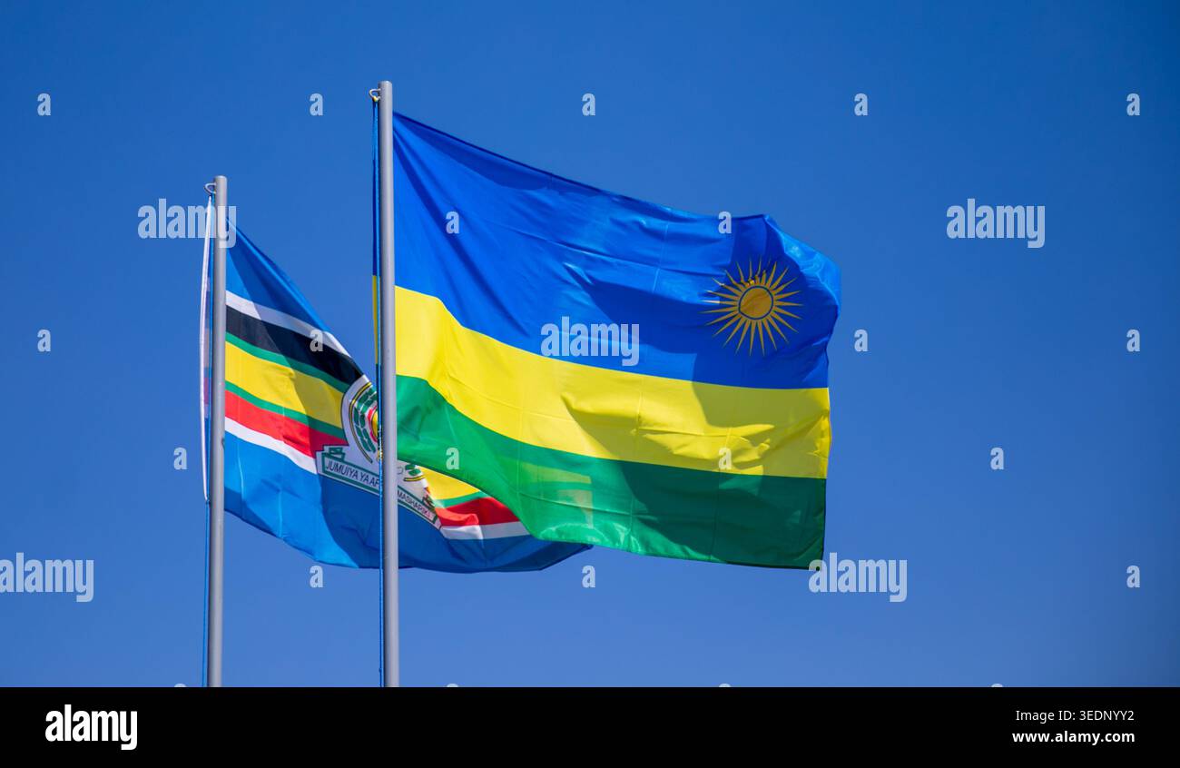 Le drapeau national du Rwanda et le drapeau de la Communauté de l'Afrique de l'est sont hissés à Kigali lors d'un événement national. Banque D'Images