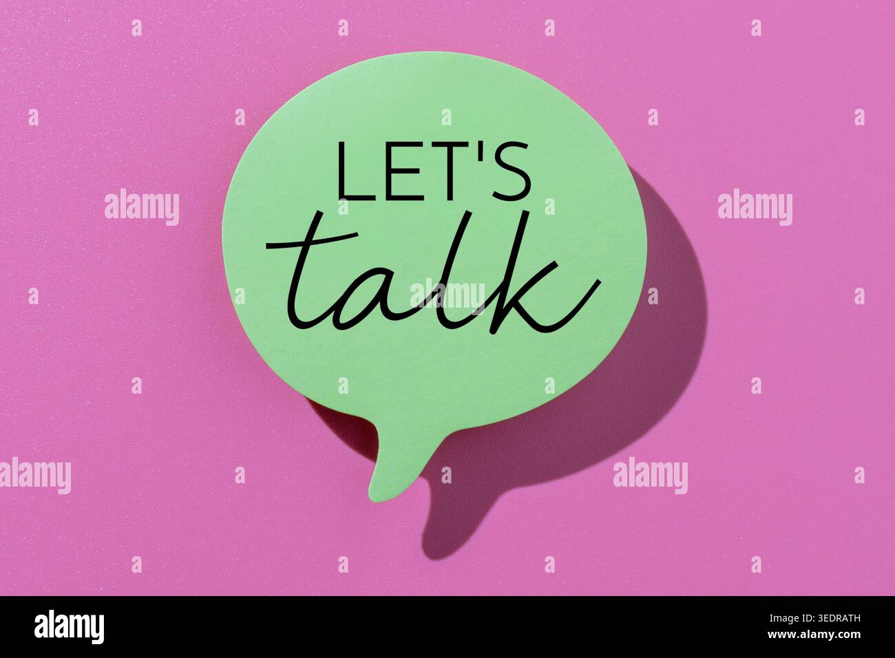 Une bulle verte avec du texte PARLONS sur fond rose vif. Communication, thérapie, counseling, concept de soutien. Banque D'Images