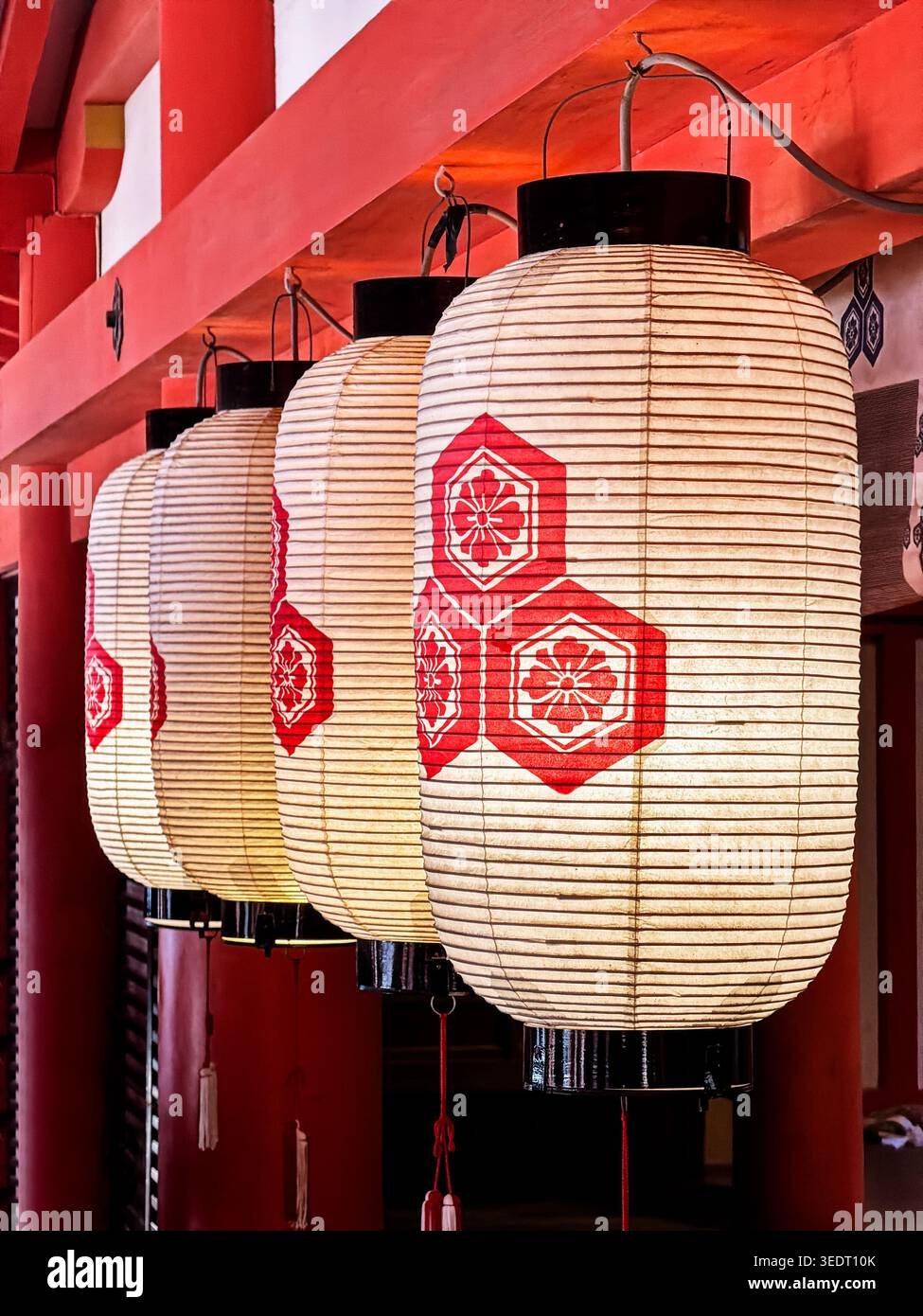 ITSUKUSHIMA, JAPON, 30 DÉCEMBRE 2025 : une petite série de lanternes en papier brillantes illuminent un passage dans un sanctuaire shinto à Itsukushima près de Hiroshi Banque D'Images