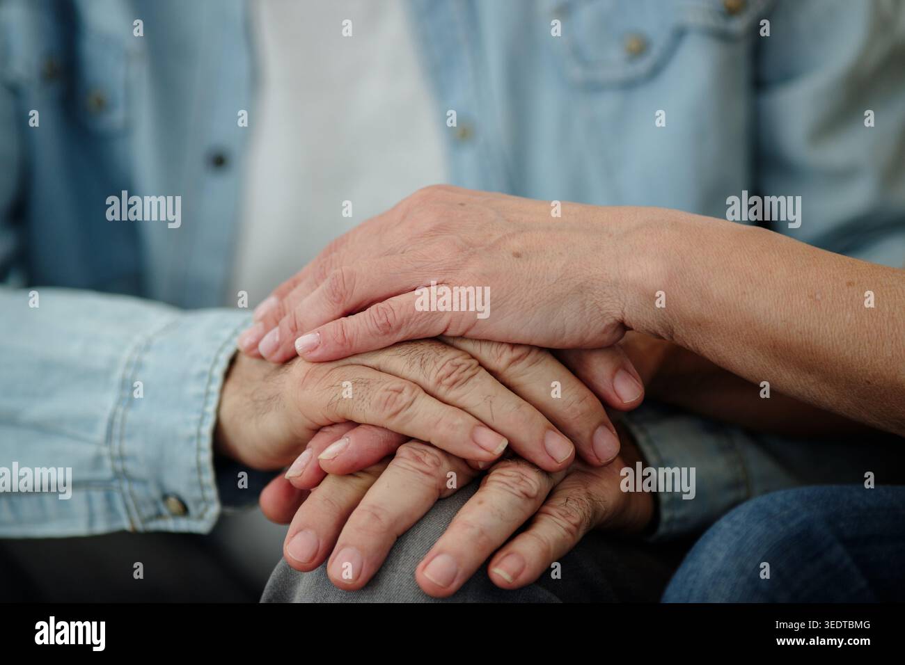 Deux mains reposent ensemble dans un geste chaleureux de soutien et de connexion entre deux personnes. Le moment capture une simple expression de soin. Banque D'Images