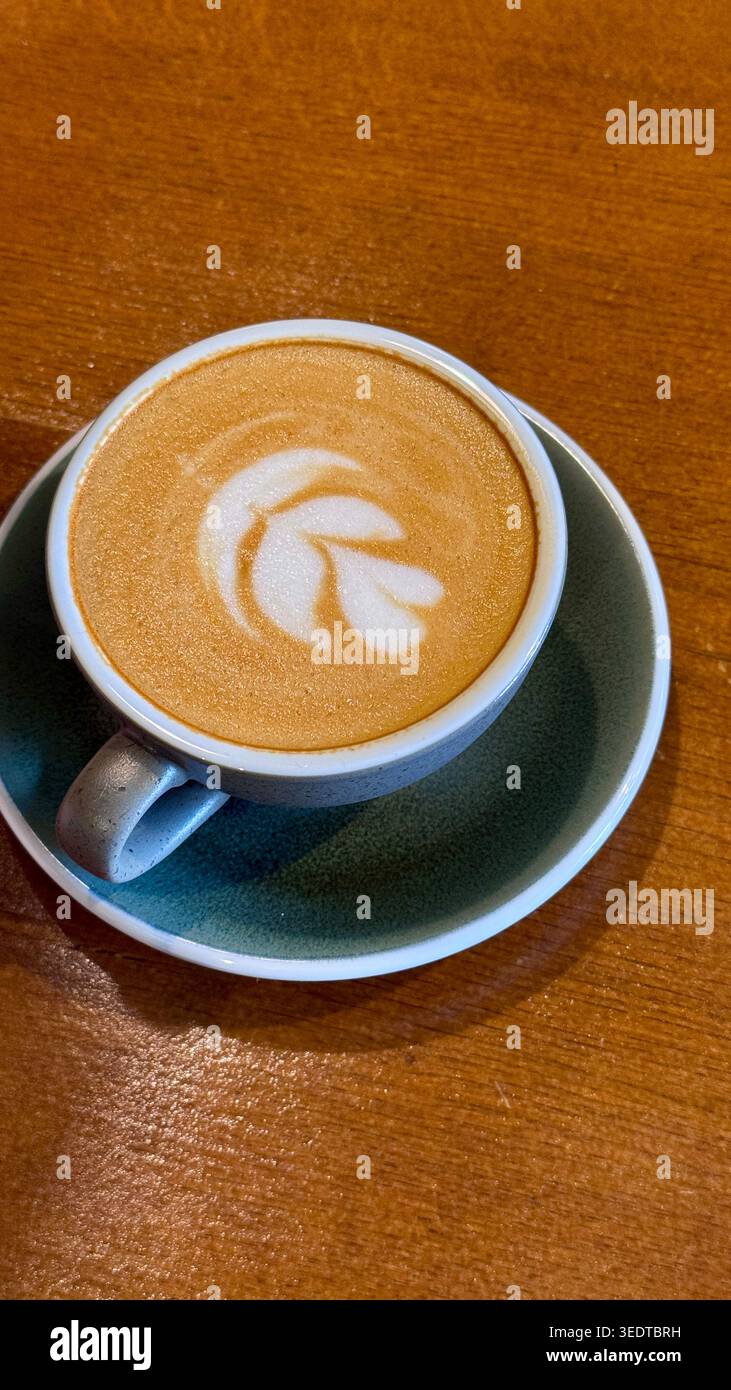 Cappuccino frais servi dans un café, avec une mousse crémeuse et une présentation minimaliste pour un concept de café et de style de vie cosy. Banque D'Images