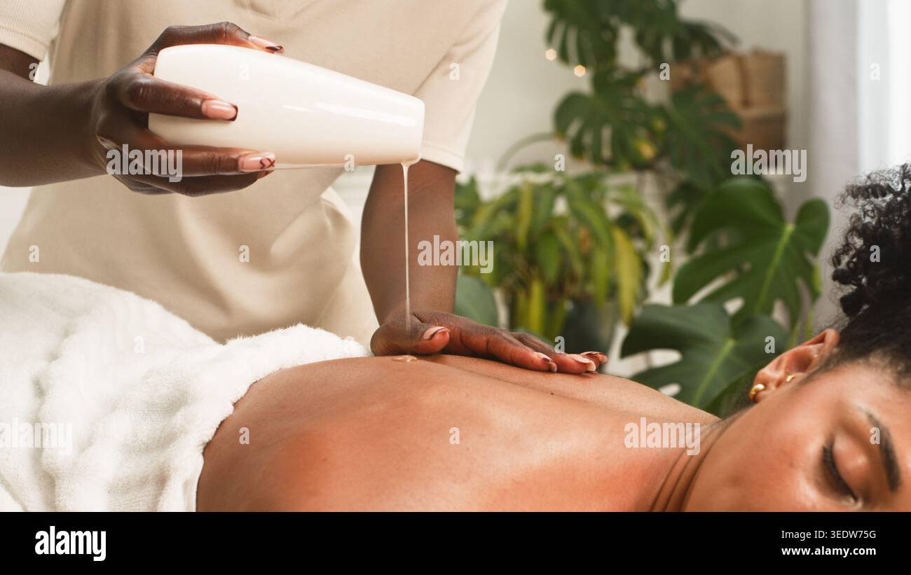 Massage relaxant à l'huile au spa avec une cliente recevant un massage du dos du thérapeute Banque D'Images