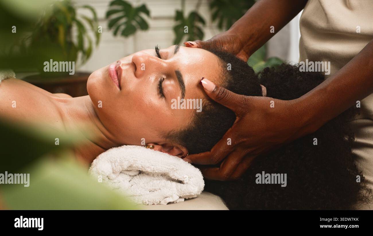 Massage relaxant de la tête dans Un spa avec femme recevant un traitement du cuir chevelu et une relaxation du visage Banque D'Images