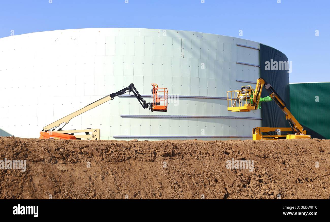 Deux cueilleurs Cherry travaillent à la construction d'un grand réservoir industriel dans l'industrie pétrolière Banque D'Images