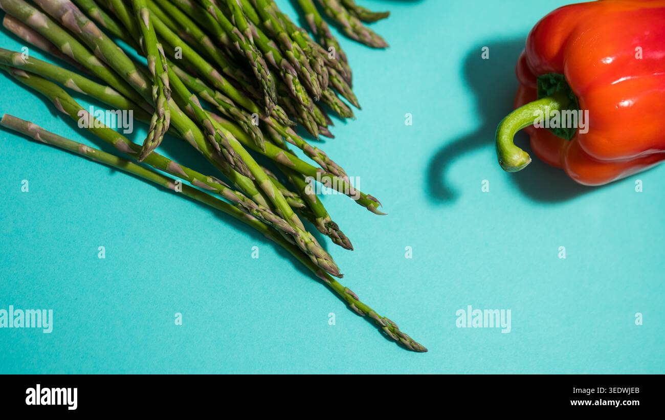 Asperges fraîches et poivrons sur fond sarcelle — photographie alimentaire de légumes colorés Banque D'Images
