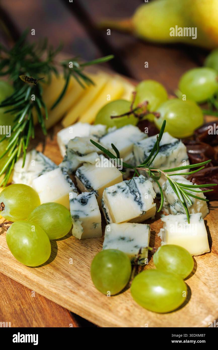 Plateau de fromage rustique avec raisins et herbes.. Banque D'Images