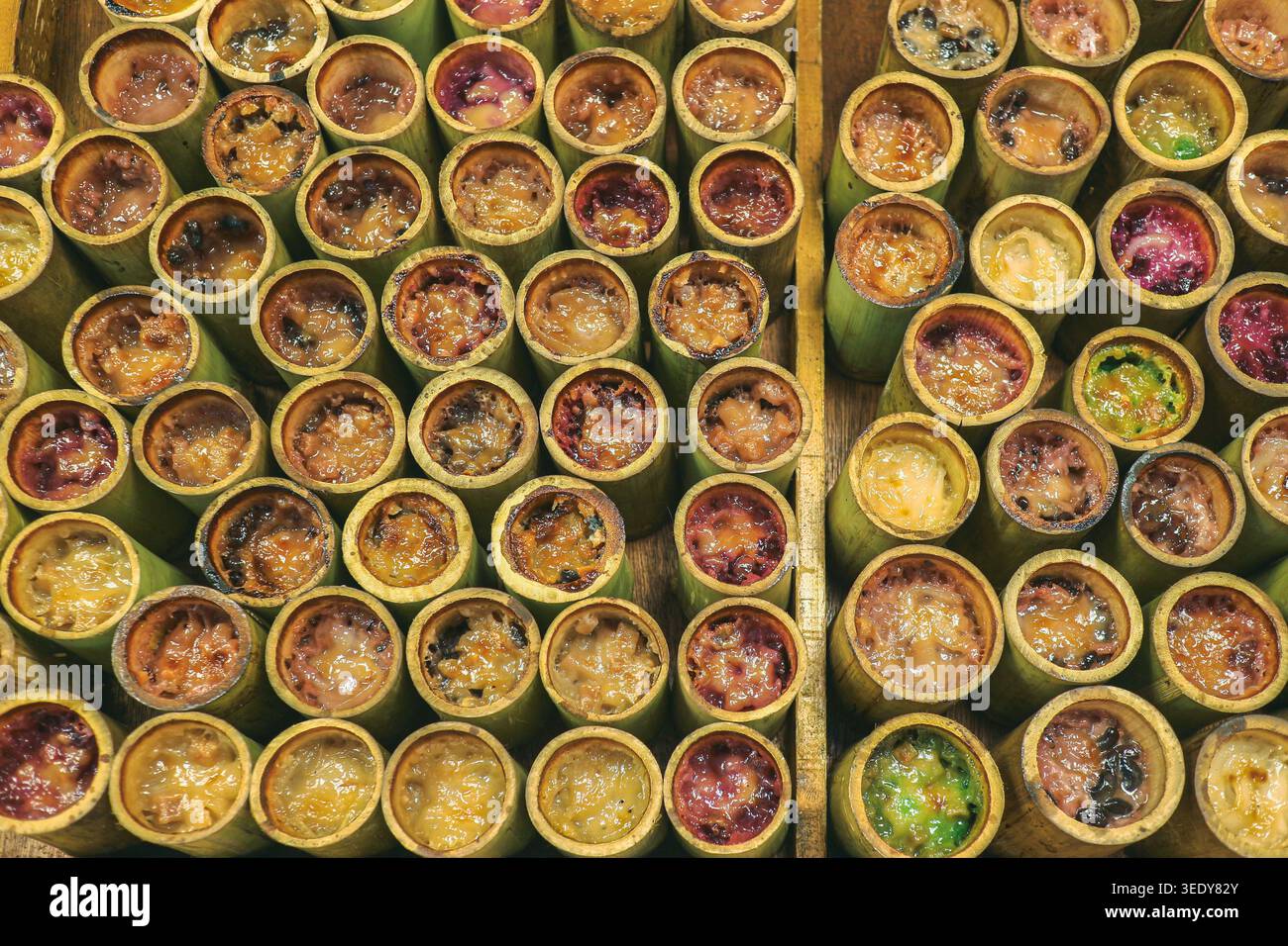 Rangées de desserts de riz collant au bambou rôti sucré. Image éditoriale haute angle représentant la culture gastronomique locale dans le centre de la Thaïlande. Banque D'Images