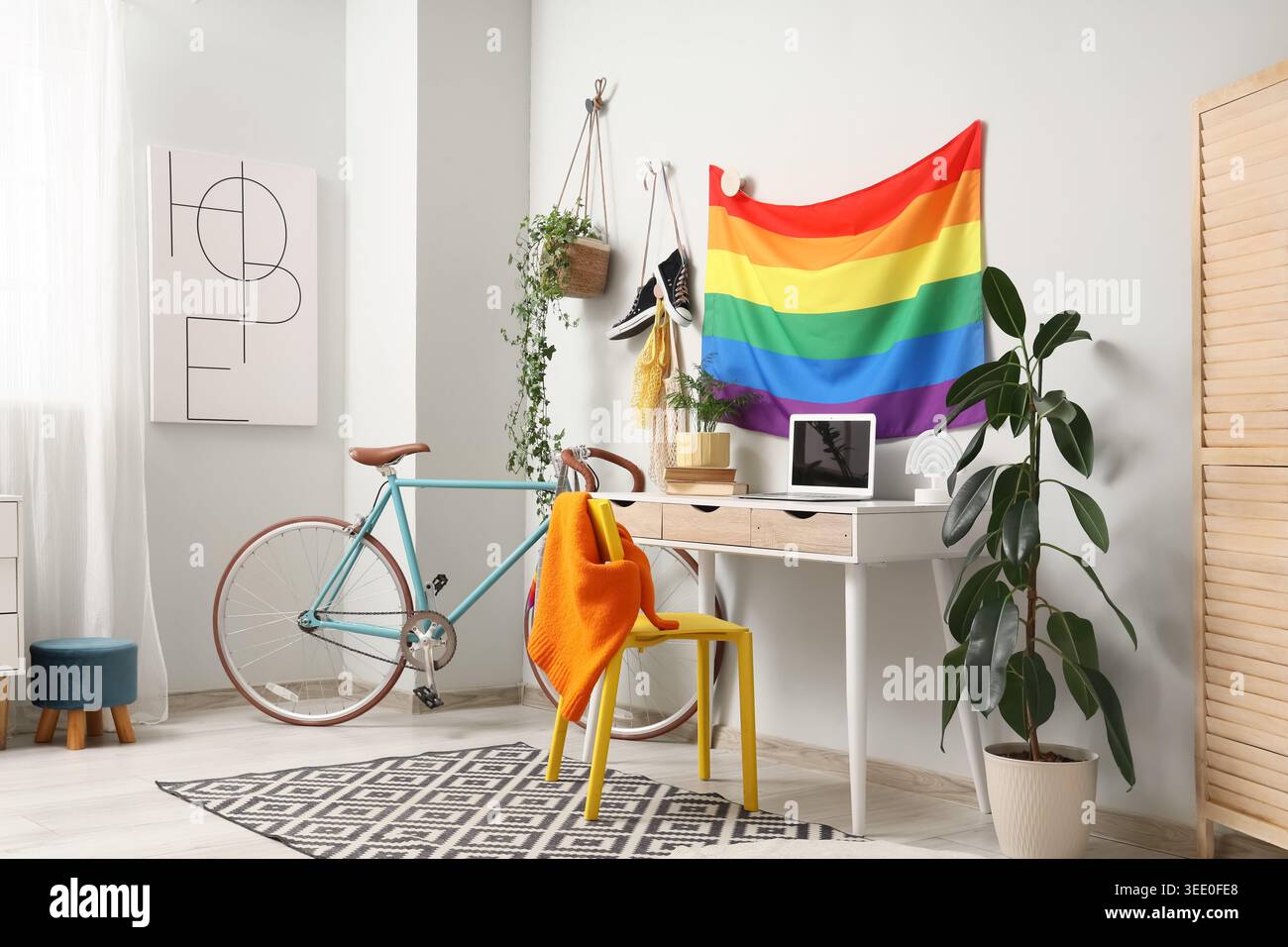 Intérieur du bureau avec drapeau LGBT, lieu de travail et vélo Banque D'Images