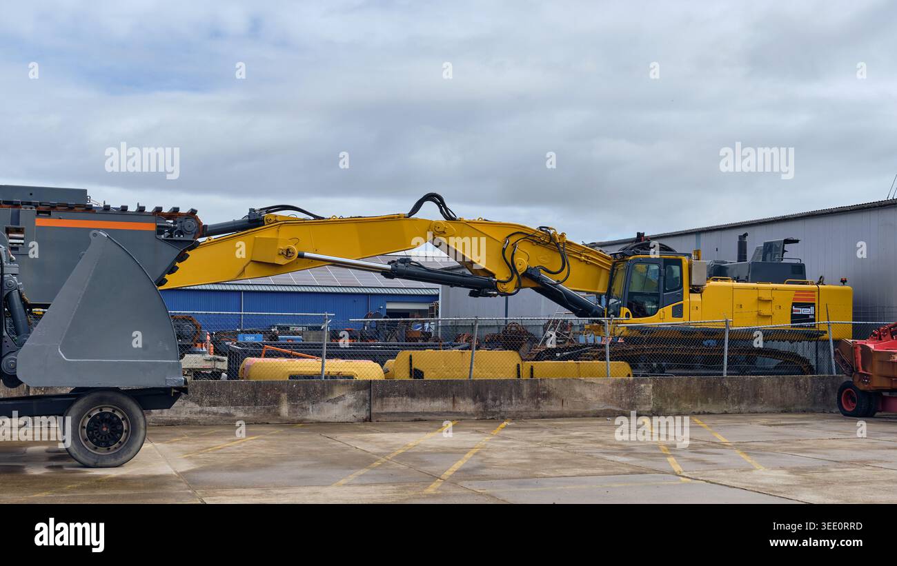 Excavatrice et équipement de dragage jaunes à usage intensif stockés dans une usine industrielle à Winkel, aux pays-Bas Banque D'Images