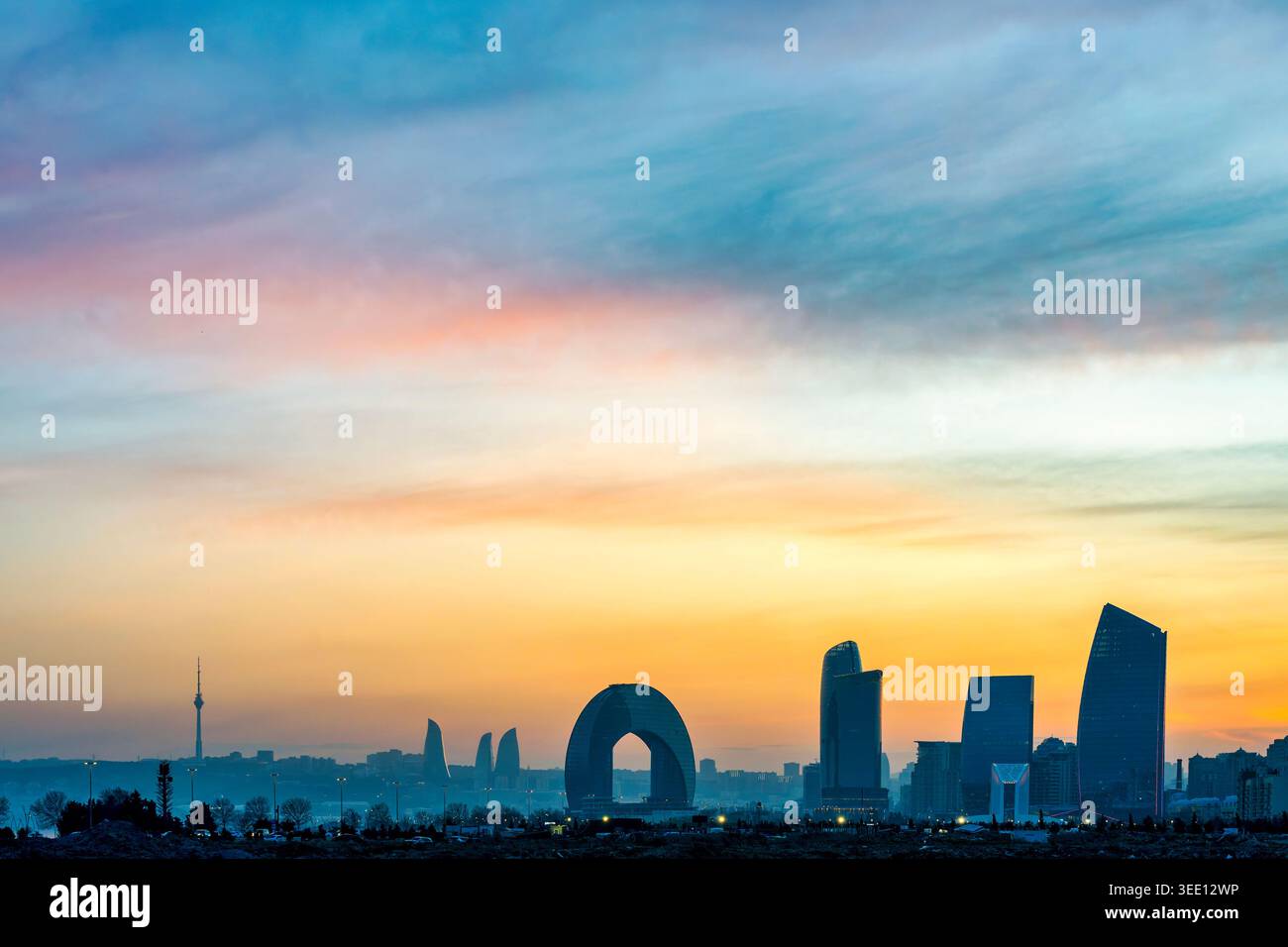 Horizon de Bakou au coucher du soleil avec Flame Towers, Crescent Hotel et Port Baku Towers silhouettées sur le ciel coloré, Azerbaïdjan Banque D'Images