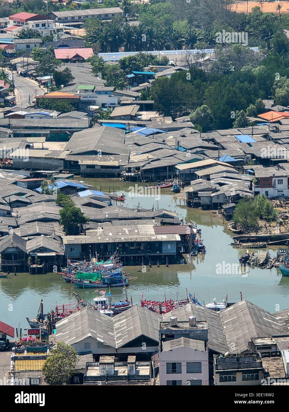 La vue aérienne capture la communauté tranquille de village de pêcheurs rustique avec une structure de maison en bois sur pilotis au-dessus de l'eau reflétant le style de vie résilient de Banque D'Images