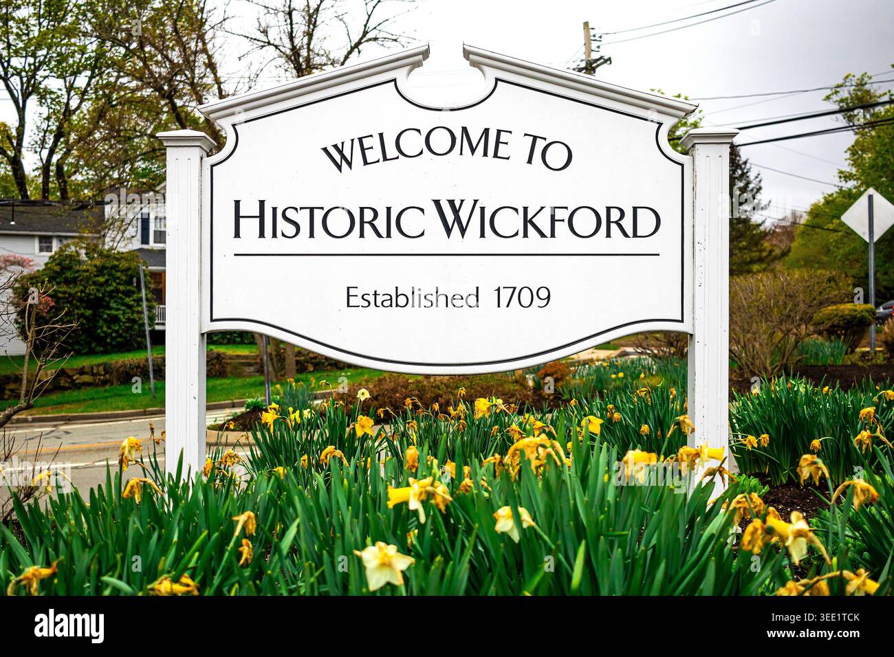 Bienvenue au panneau historique de Wickford dans le village de Wickford, Middletown, Rhode Island, avec des jonquilles plantées dans la médiane Banque D'Images