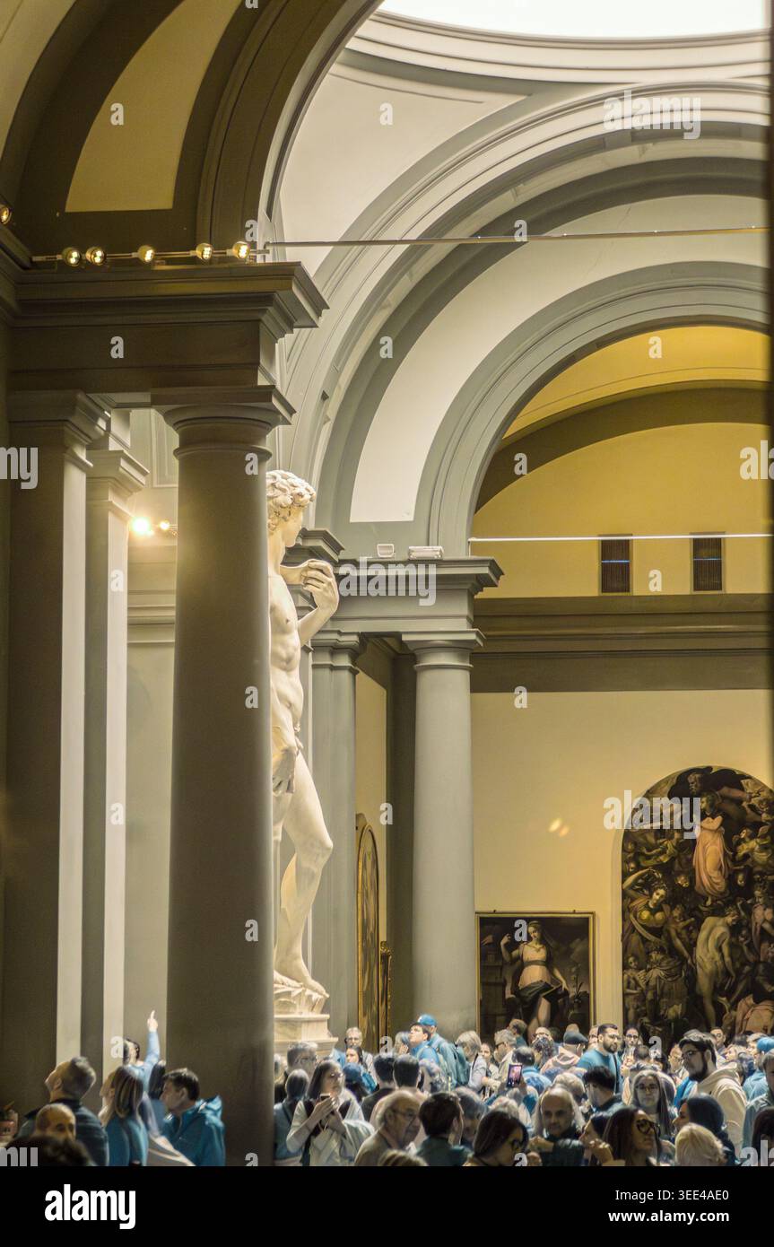 L'emblématique statue de David en marbre de Michel-Ange se trouve en bonne place dans la Galleria dell'Accademia de Florence, en Italie, attirant une grande foule de touristes divers Banque D'Images