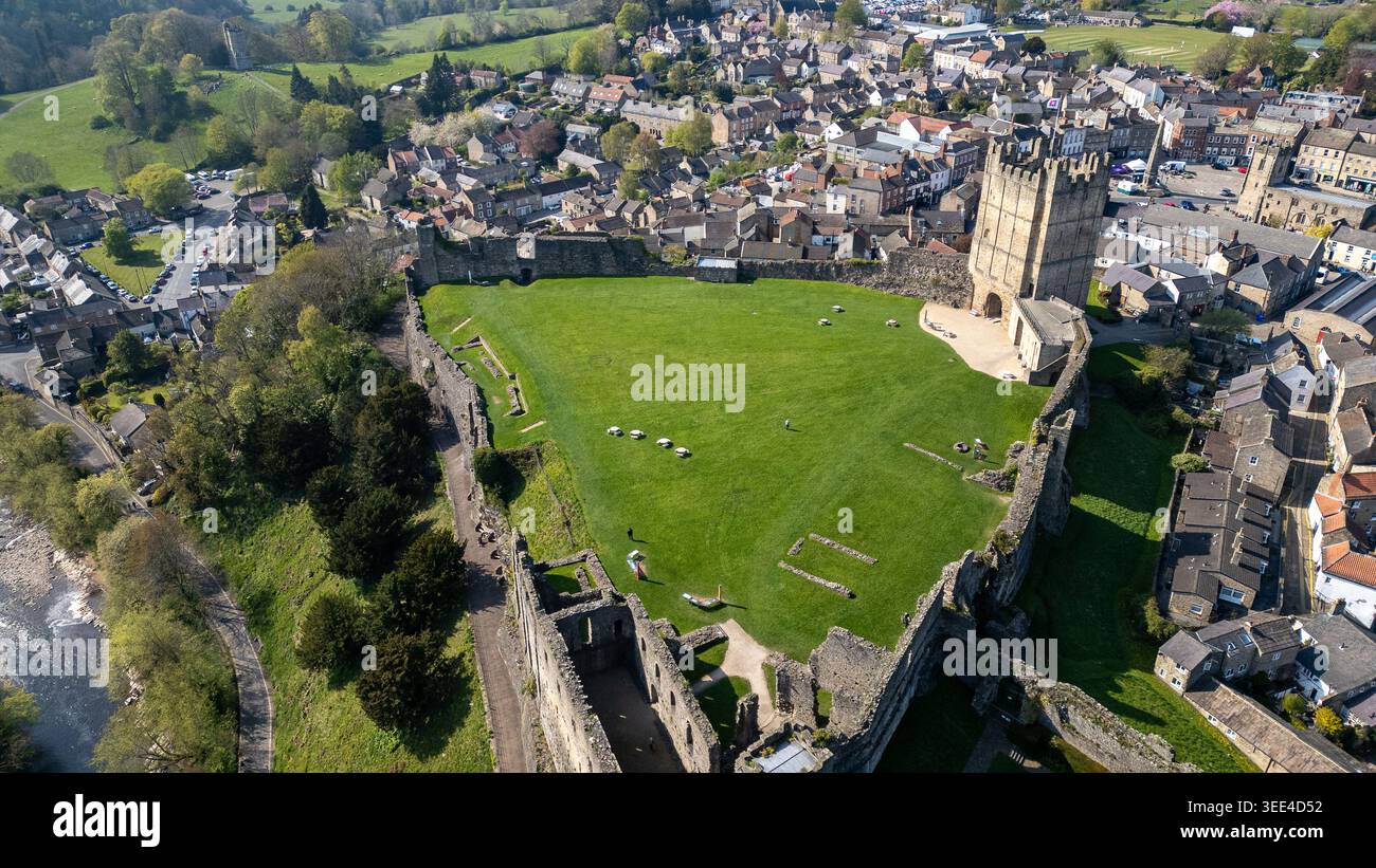 Vue aérienne des ruines historiques du château entouré d'une pelouse verdoyante et de bâtiments de la ville de Richmond, North Yorkshire, Royaume-Uni. Banque D'Images