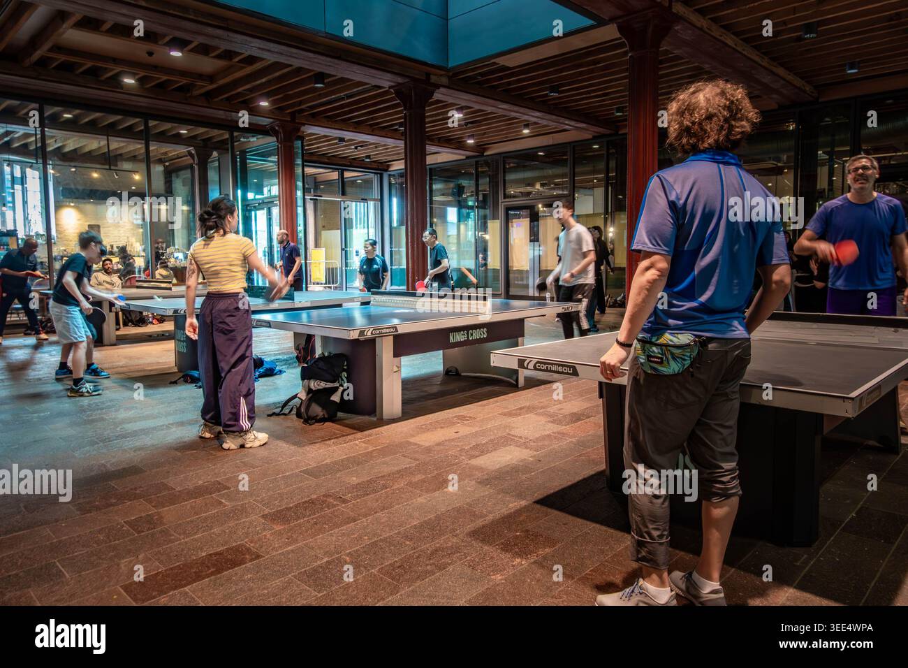Les gens jouant au tennis de table sur les tables de tennis de table communales dans le marché Canopy dans la région de King's Cross à Londres, Royaume-Uni Banque D'Images