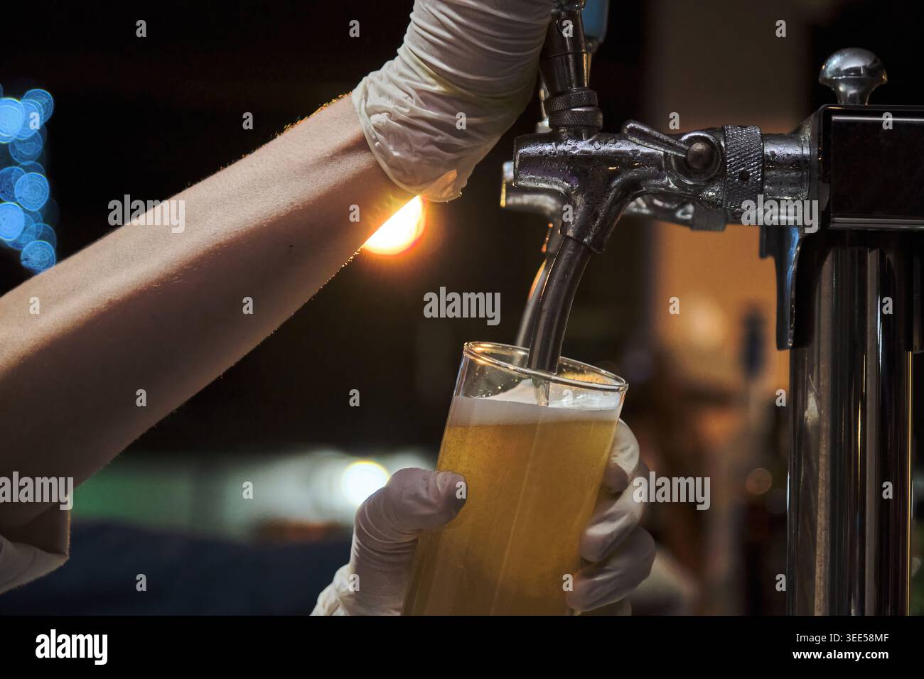 un homme versant de la bière dans une grande tasse de bière claire en fête Banque D'Images