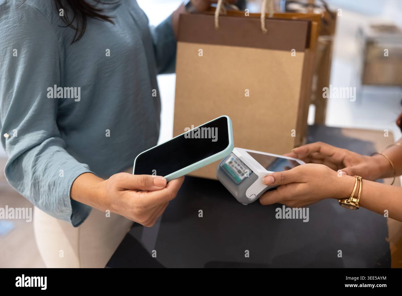 Gros plan d'une femme utilisant son smartphone pour effectuer un paiement sans contact Banque D'Images