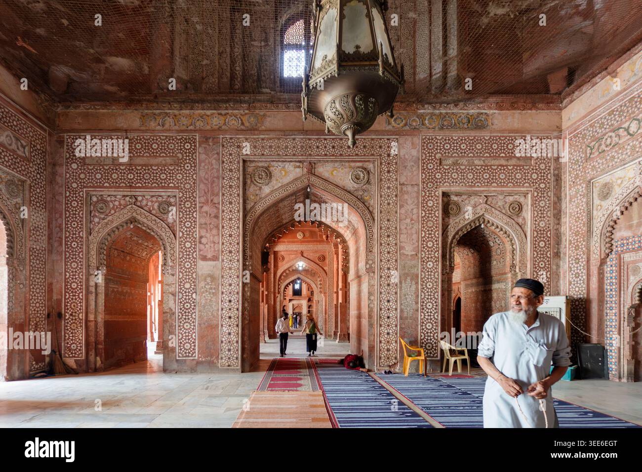 Vue intérieure du Jama Masjid à Fatehpur Sikri montrant des arcs en grès rouge complexes et des motifs géométriques et un grand lustre suspendu en laiton Banque D'Images