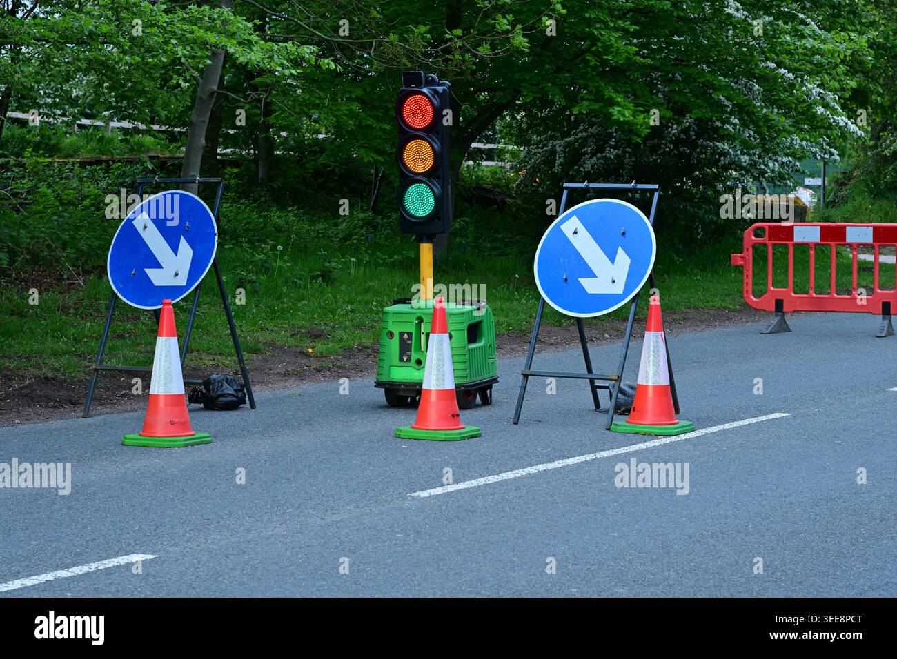 Feux de circulation temporaires et cônes sur la route rurale étroite Banque D'Images
