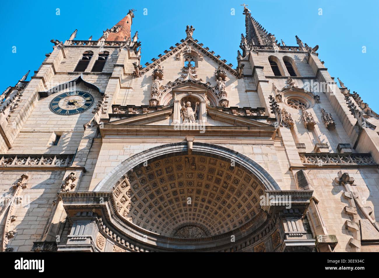 Lyon, France - 12 mai 2026 : façade de l'église Saint-Nizier avec des tours asymétriques, une flèche gothique et un portail à caissons Renaissance. Banque D'Images