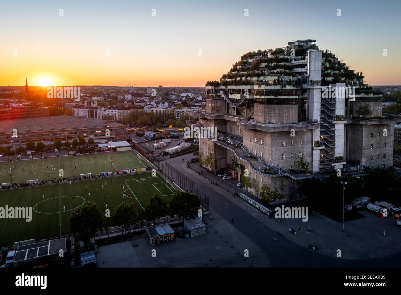 Hambourg, Allemagne - 01 mai 2026 : vue aérienne du green de Pauli Bunker à Heiligengeistfeld pendant le coucher du soleil, avec un terrain de football et le skyli de la ville Banque D'Images