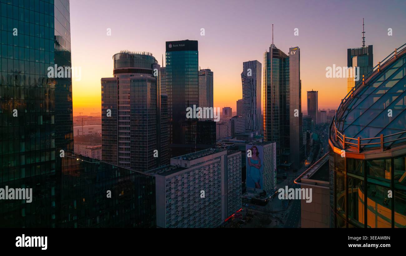 Varsovie, Pologne - 07 mars 2026 : vue aérienne de la ville moderne avec des gratte-ciels en verre reflétant la lumière dorée du coucher de soleil sur le paysage urbain Banque D'Images