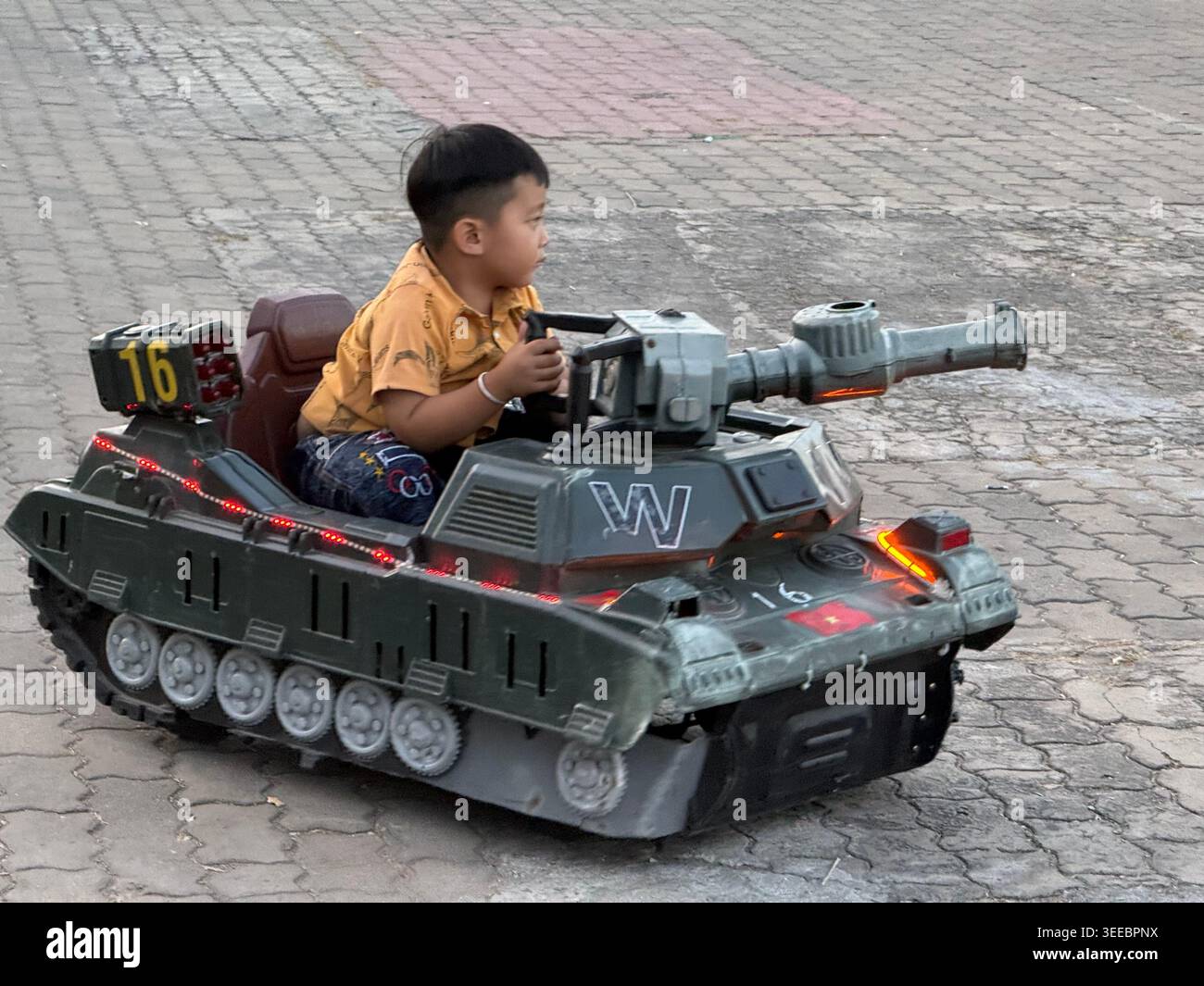 Les parents se joignent au plaisir en contrôlant leurs mini voitures childÕs radiocommandées dans le parc 30 Thang 4 sur la promenade principale de Chau Doc cityÕs, face au confl - Image de stock capturée avec un smartphone