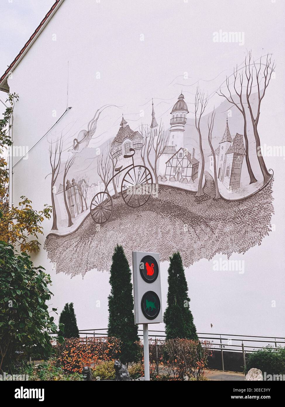 Zelenogradsk, Russie- octobre 26 2021 : murale fantaisiste d'un vélo vintage et ville fantastique sur un mur blanc avec circulation piétonne décorative Banque D'Images