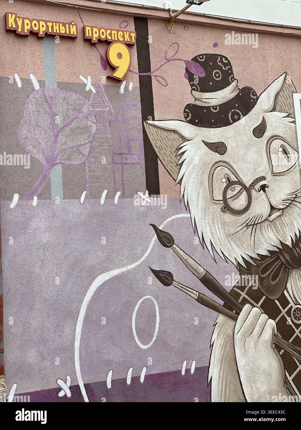 Zelenogradsk, Russie - octobre 26 2021 : murale créative d'un artiste de chat fantaisiste tenant des pinceaux sur un mur de la ville avec des détails de panneau de rue - Image de stock capturée avec un smartphone