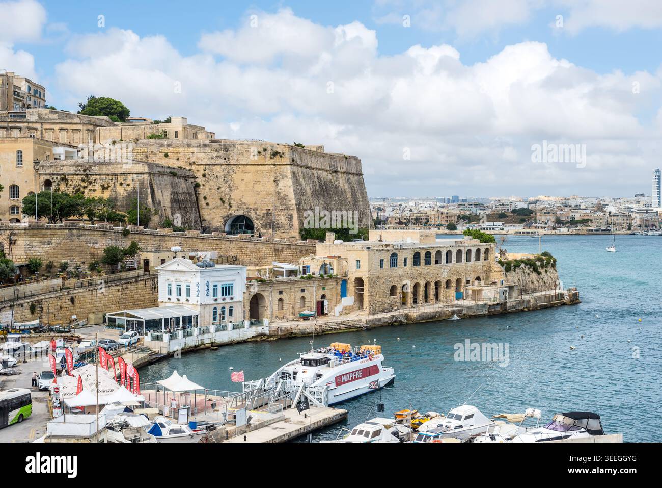 Sliema, Malte – 16 mai 2025 : vue sur les fortifications en pierre historiques, la marina et l'architecture du front de mer le long de la côte méditerranéenne avec des bateaux et h Banque D'Images