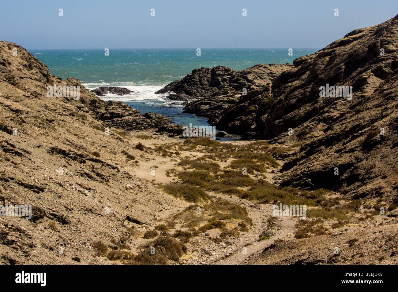 Petit sentier 4X4 descendant vers l’océan entre les affleurements rocheux de la péninsule de Lüderitz, en Namibie Banque D'Images