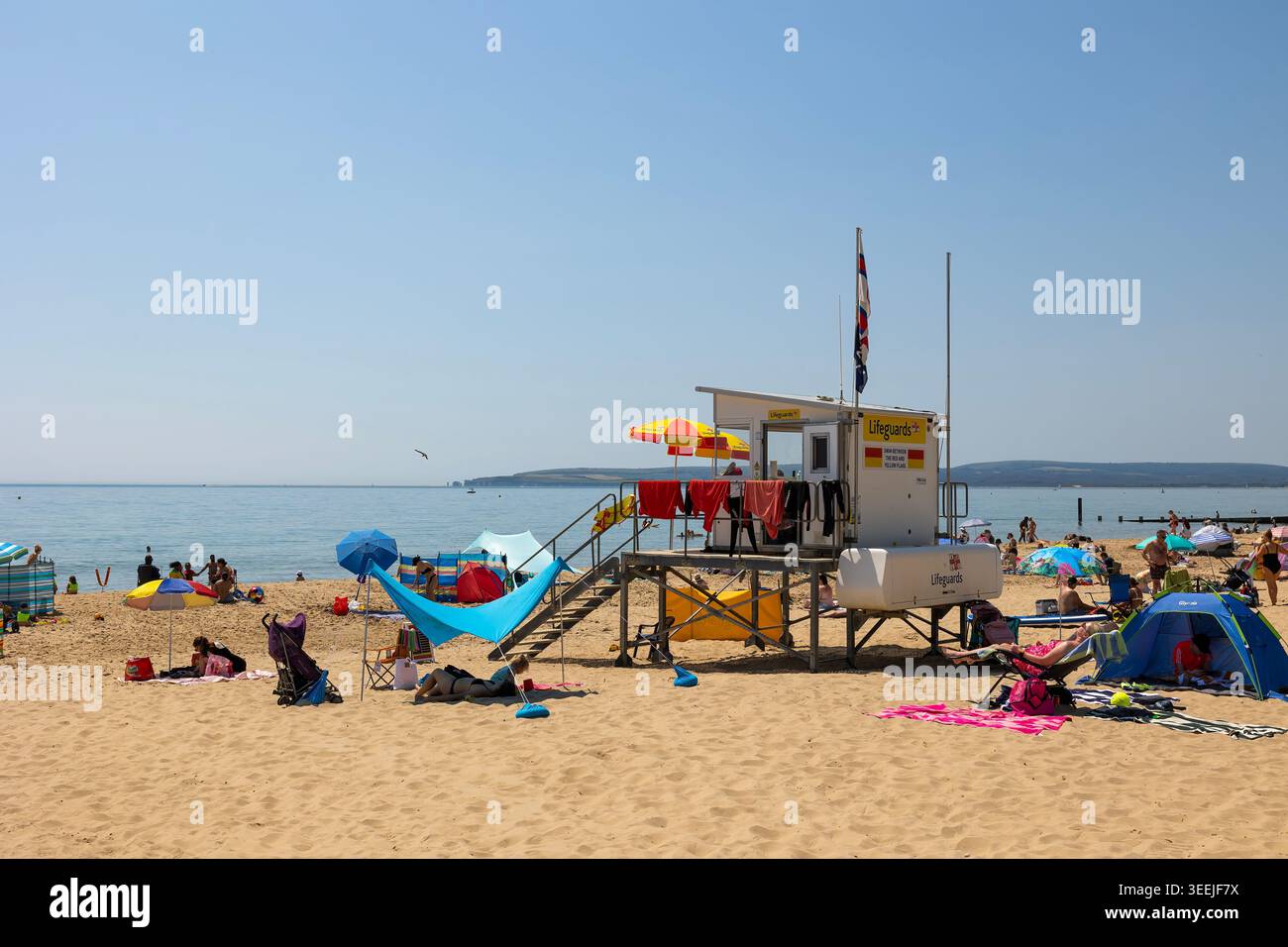 Poste de sauveteur de plage de Bournemouth sous un ciel lumineux d'été — poste de sécurité RNLI surplombant le rivage animé. Banque D'Images