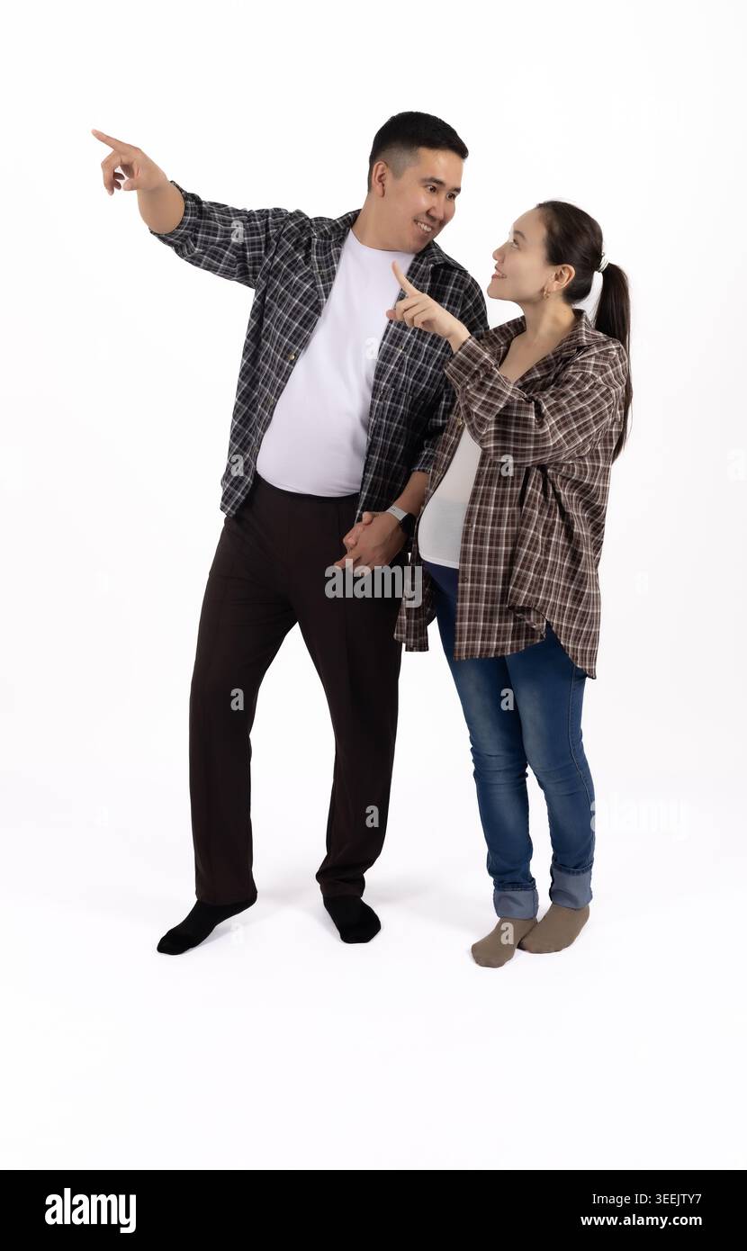 Homme et femme debout ensemble, homme pointant vers le haut pour photo professionnelle... Banque D'Images
