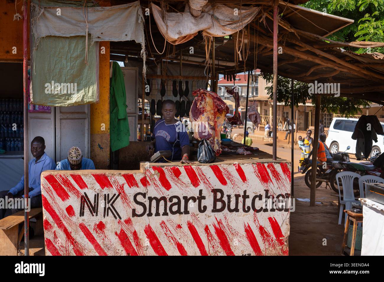 Boucherie en bord de route en Ouganda avec un vendeur de rue vendant de la viande. Banque D'Images