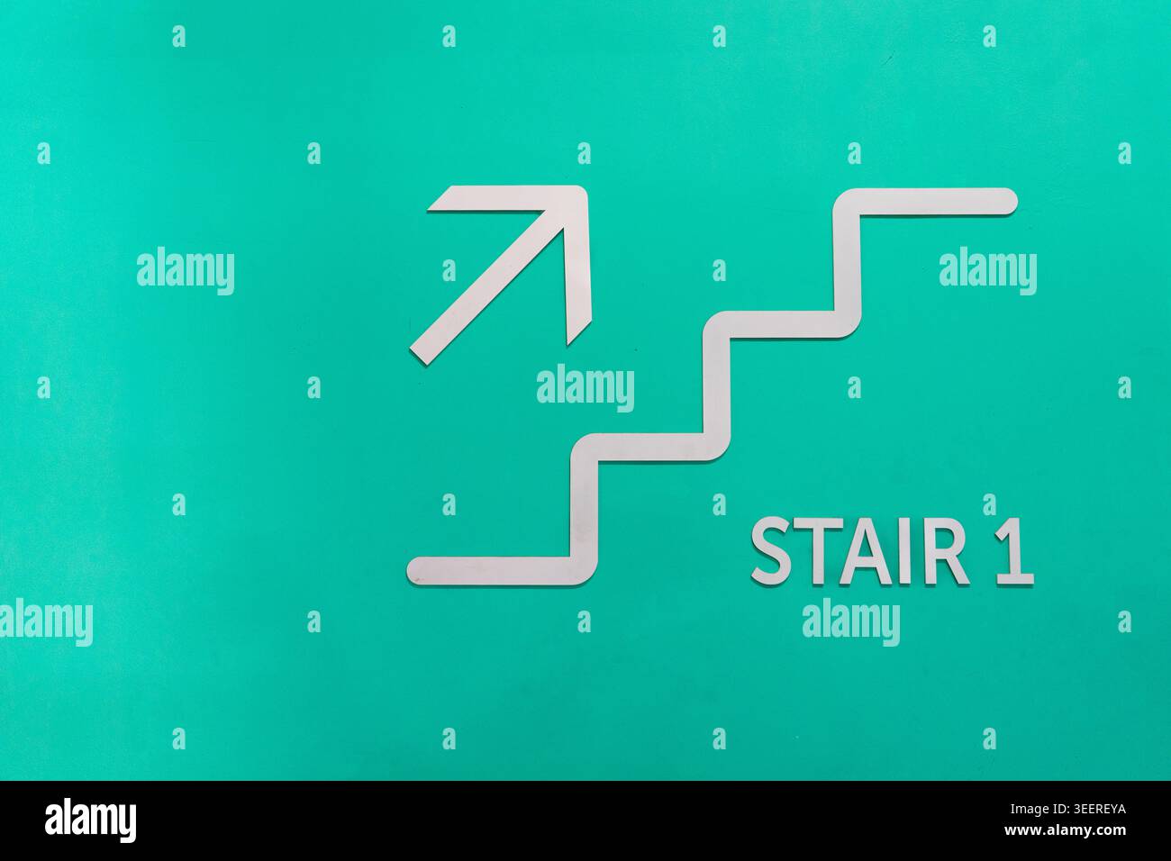 Un panneau architectural épuré et contemporain avec un motif d'escalier blanc, une flèche pointant vers le haut et le texte « STAIR 1 » monté sur un te vibrant Banque D'Images