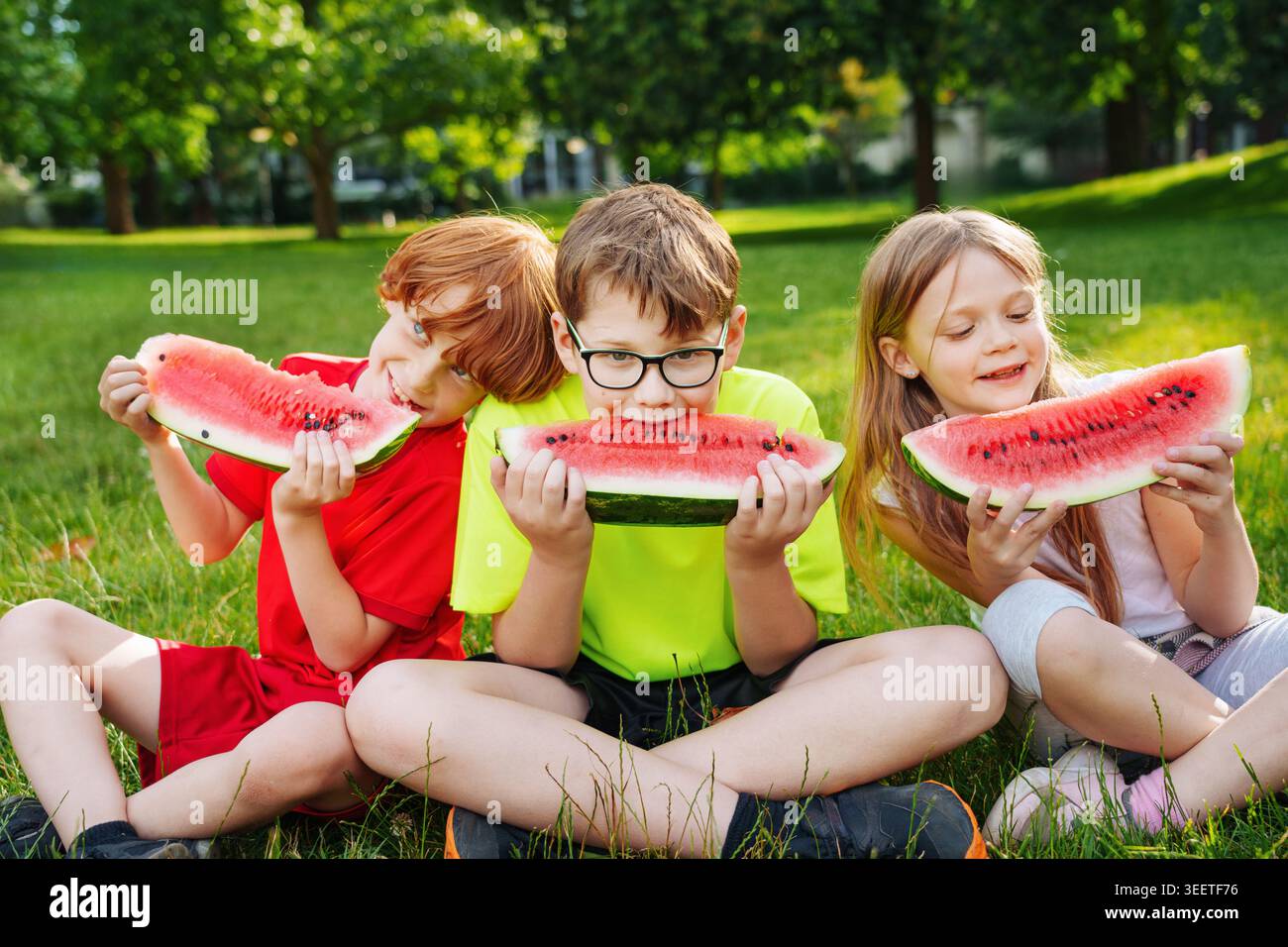 Groupe d'enfants mangeant de la pastèque à l'extérieur en été. Profitez des journées ensoleillées avec wasselmelon sucré. Banque D'Images