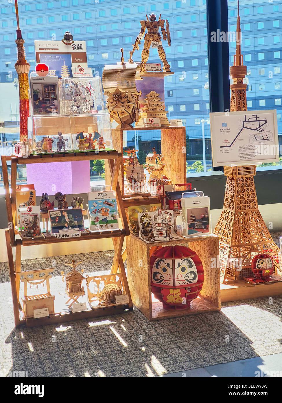 Un présentoir de vente au détail met en valeur des modèles de puzzles 3D en bois complexes et des miniatures architecturales disposées sur des étagères en bois rustiques positionnées à proximité Banque D'Images