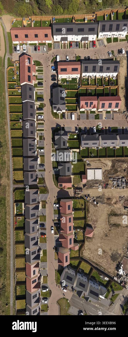 Vue aérienne du développement de logements résidentiels modernes avec des rangées de maisons dotées de panneaux solaires et de jardins verdoyants. Banque D'Images