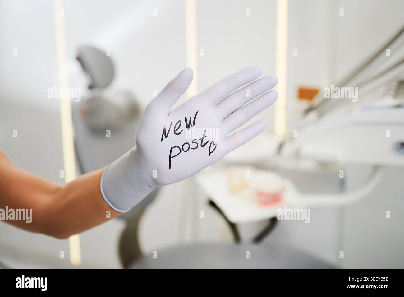 Dentiste main dans le gant montre Nouveau texte post dans le cabinet dentaire. Concept créatif de soins de santé pour les médias sociaux cliniques, promotion en ligne, communication avec les patients Banque D'Images
