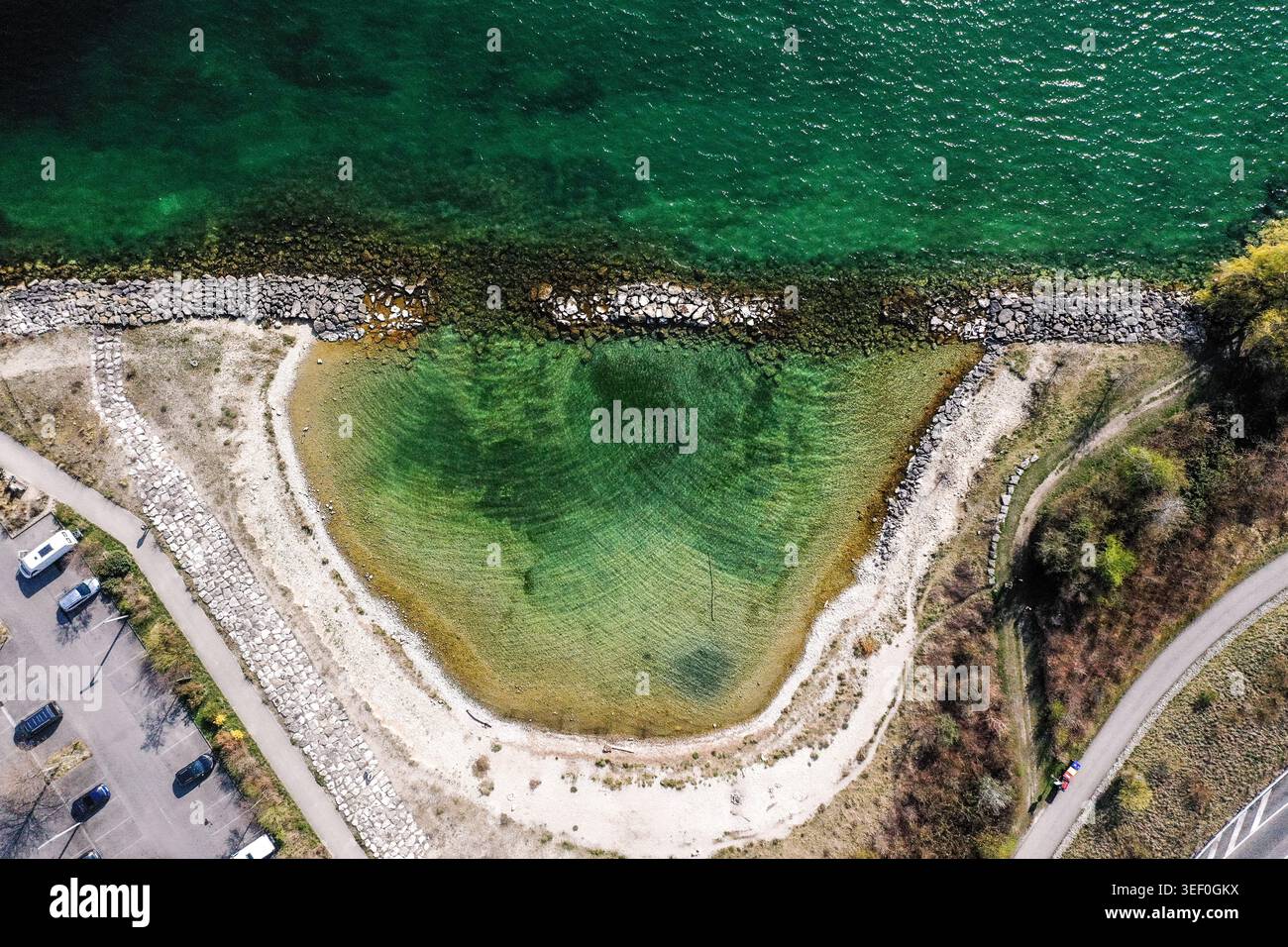 Plage de galets en croissant et baie turquoise peu profonde - vue aérienne du lac Neuchâtel à Serrières, Suisse Banque D'Images