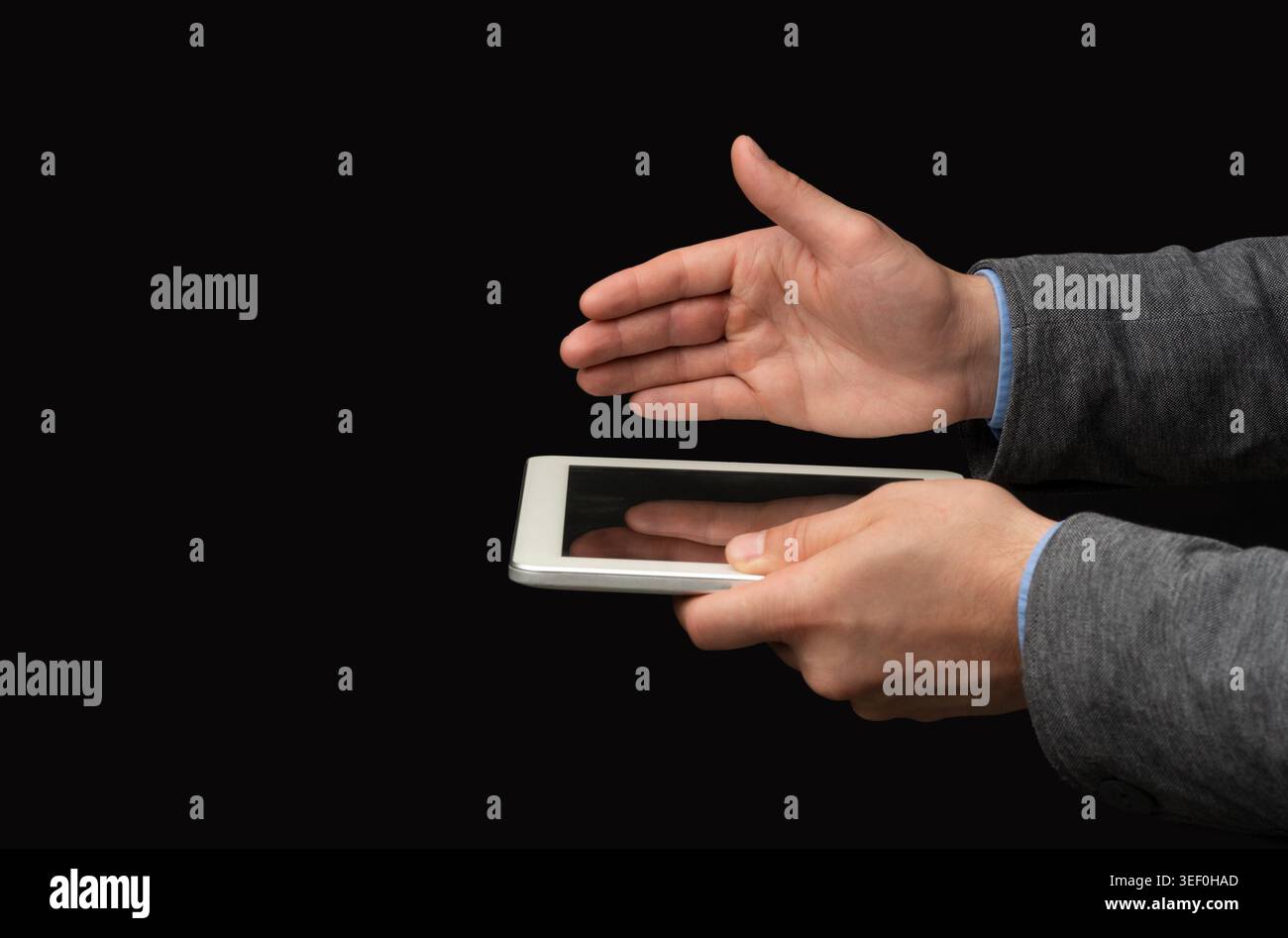 Mains interagissant avec une tablette dans un environnement sombre pendant une activité numérique Banque D'Images
