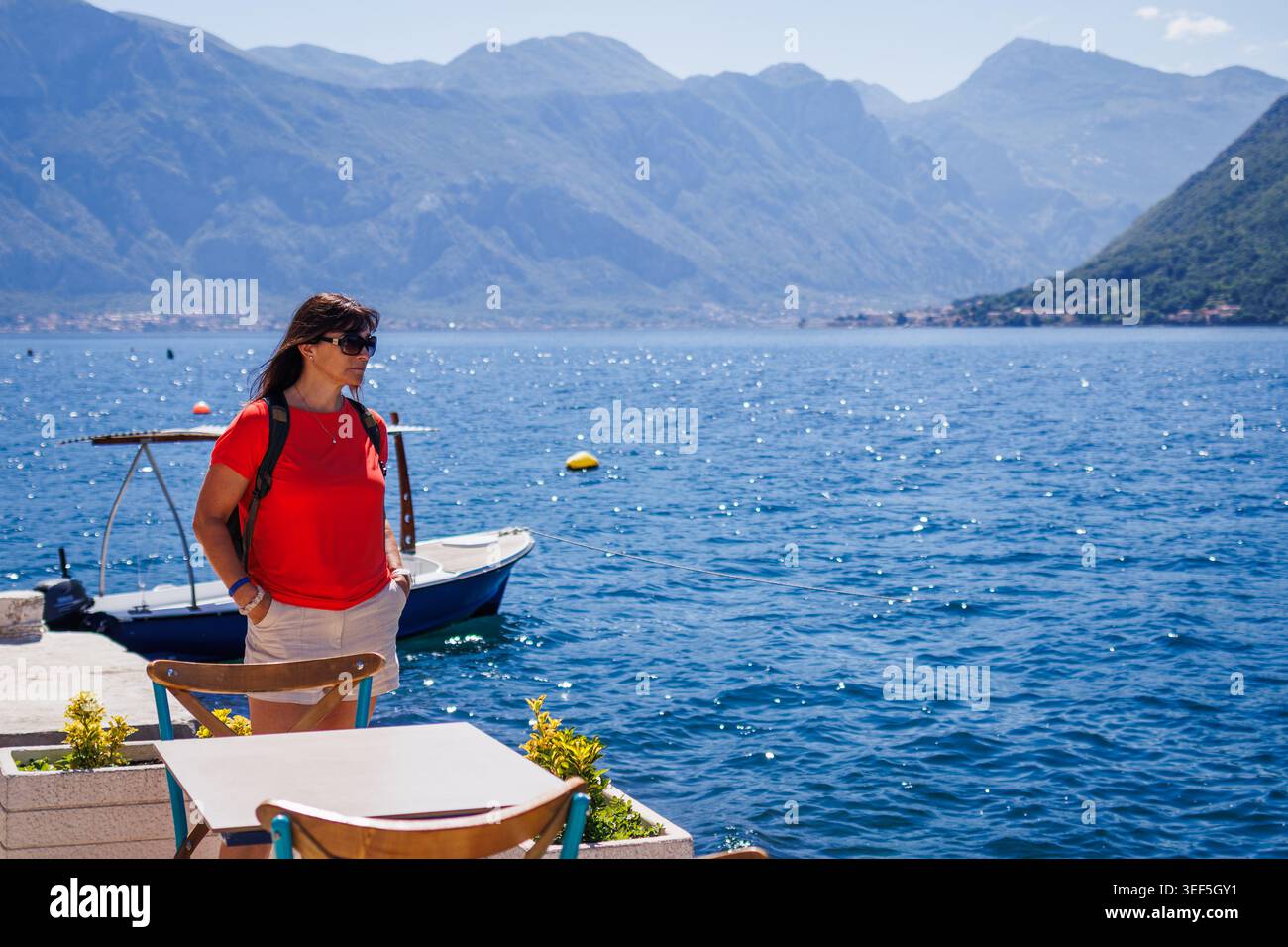 Femme voyageuse en solo explorant la ville de Kotor au Monténégro. Touriste féminine regardant la baie de la mer et les montagnes environnantes. Vacances d'été actives Banque D'Images
