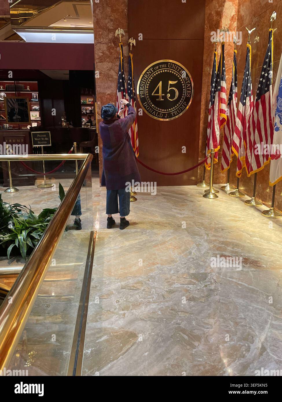 Femme touriste prenant une photo à Trump's POTUS Display and Flags, Trump Tower, 2026, NYC, États-Unis Banque D'Images