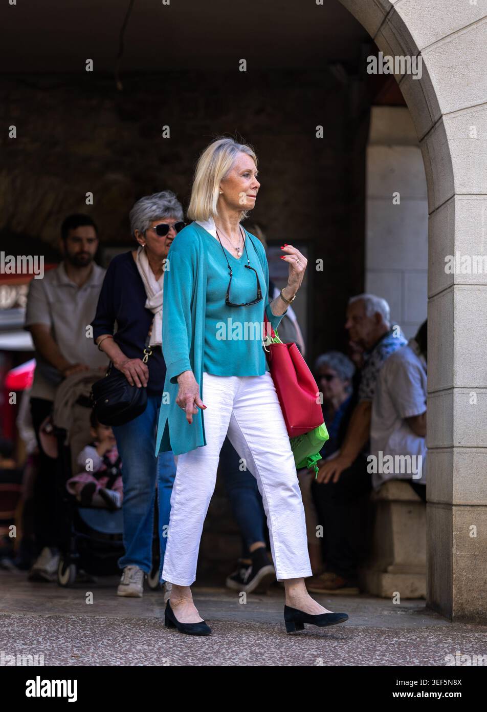 Dijon, France - 9 mai 2026 : une femme mature élégante de plus de 60 ans marchant dans le centre-ville avec un sac à main. Style de vie élégant et retraite active Banque D'Images